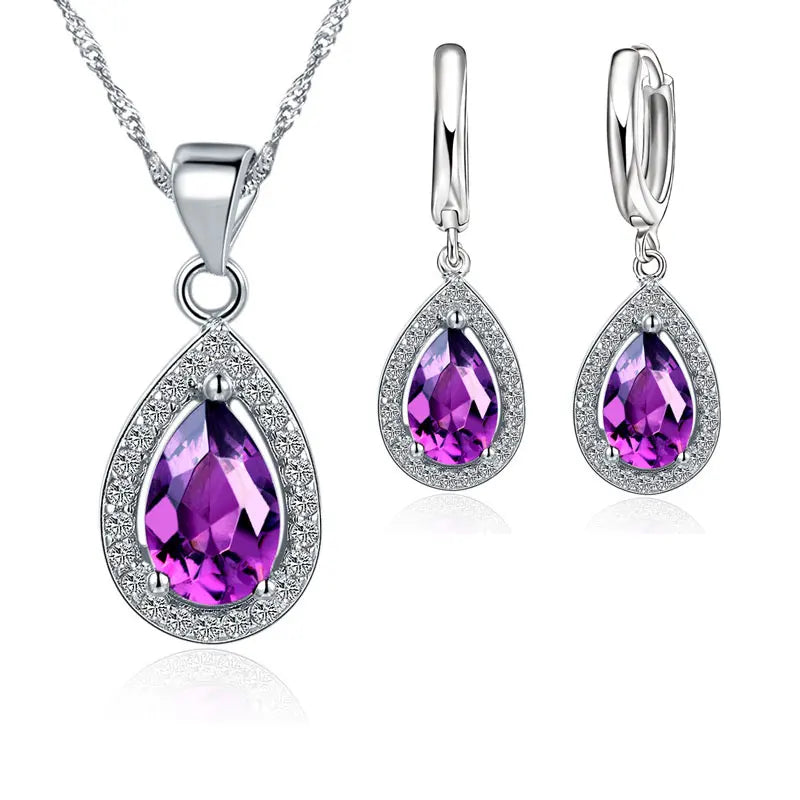 Jewelry set with purple teardrop-shaped gemstones on a white background