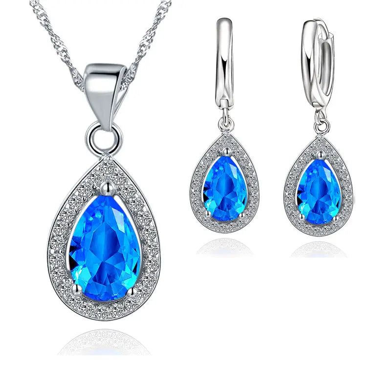Jewelry set with blue teardrop stones on a white background