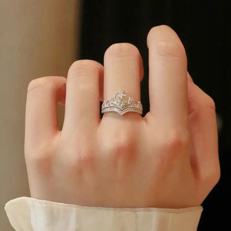 Close-up of a hand wearing a silver ring with a detailed design.