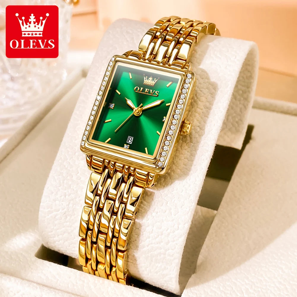 Gold wristwatch with green face on a white cushion, OLEVS brand visible