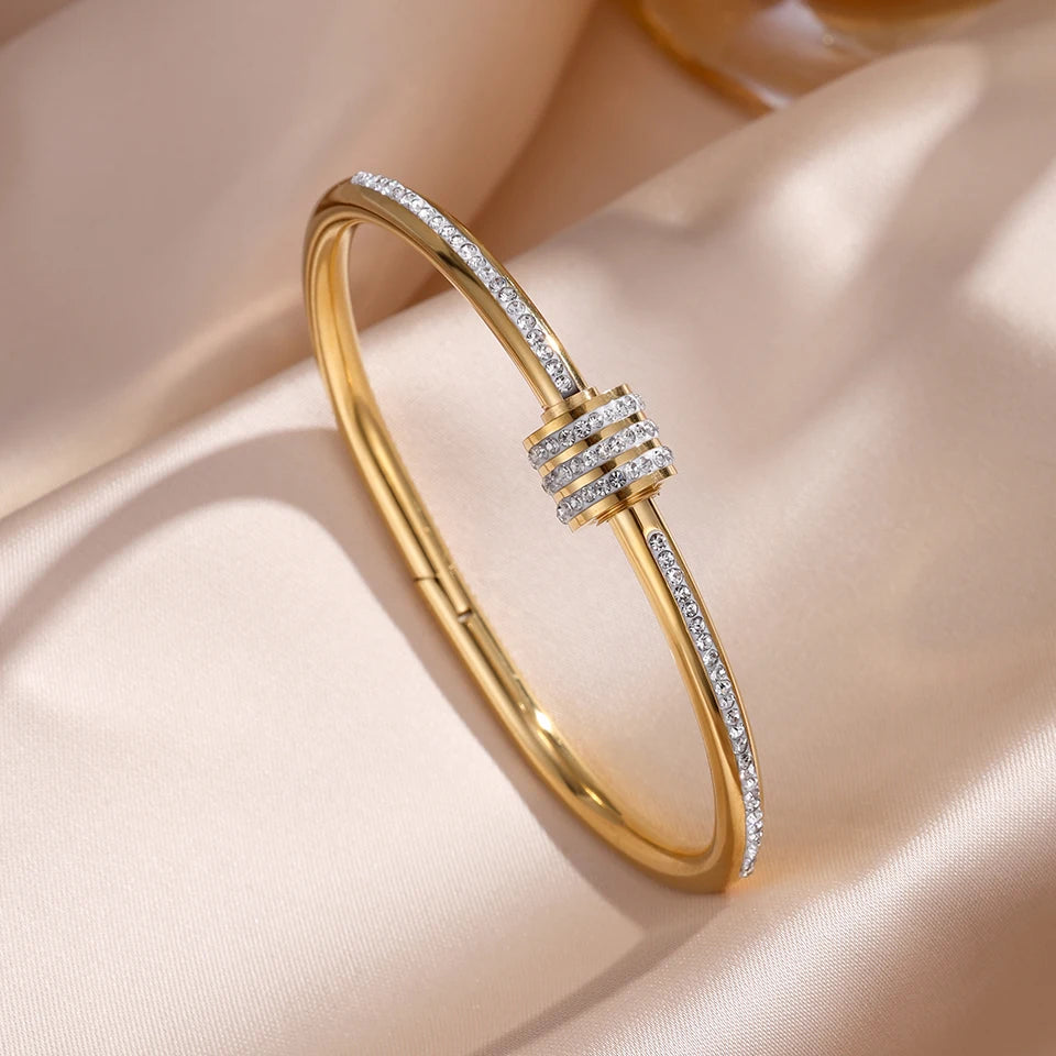 Gold bracelet with diamond accents on a beige fabric background