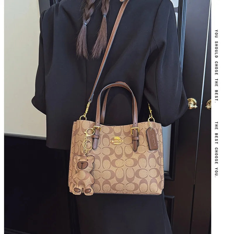 Person wearing a Coach handbag with a visible brand logo.