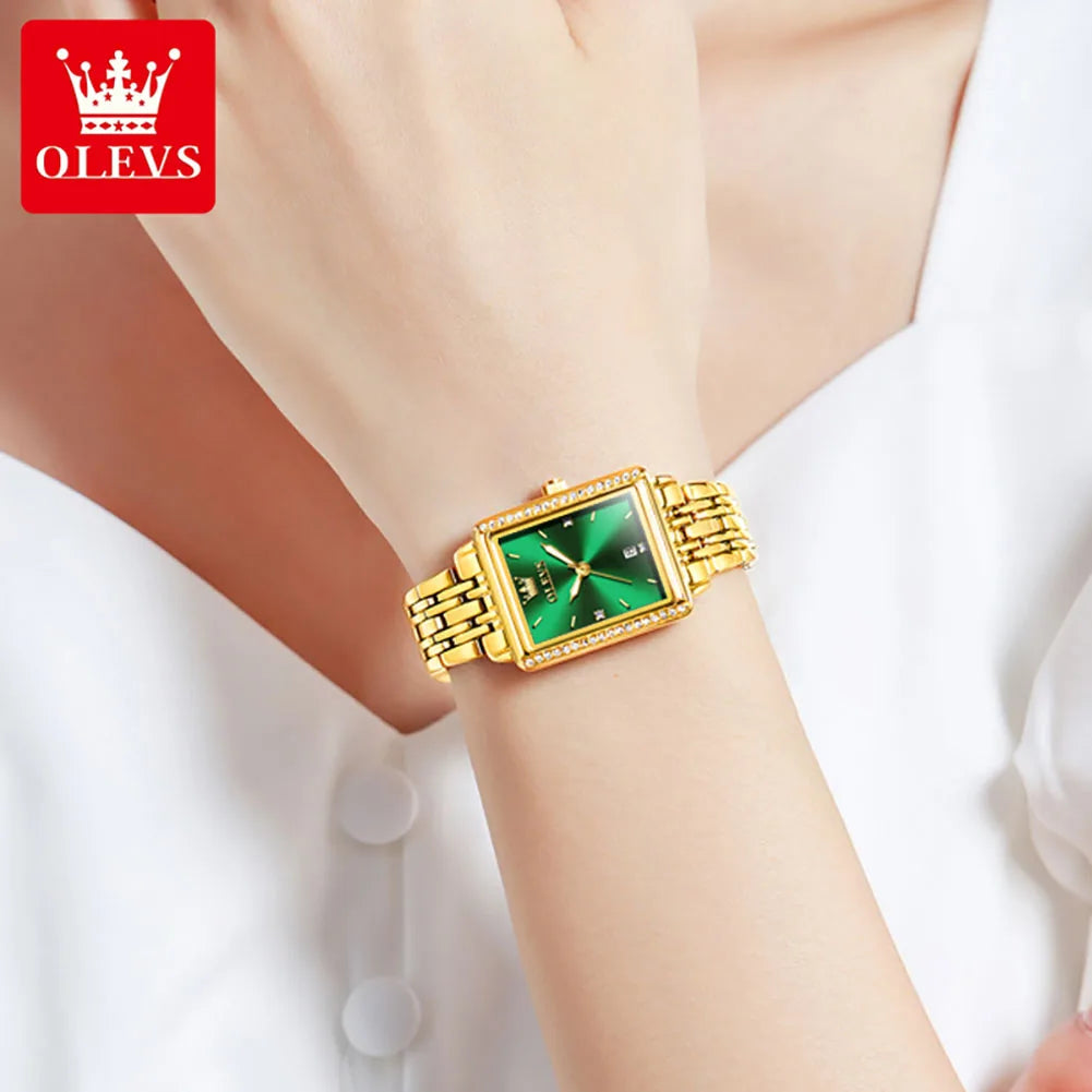 Gold wristwatch with green face on a person's wrist, brand 'OLEVS' visible.