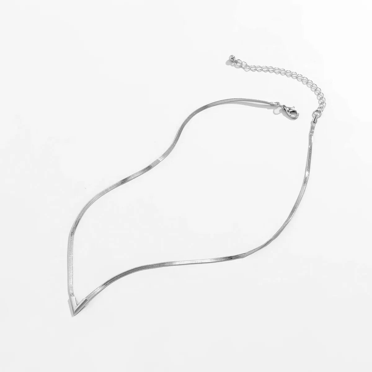 Silver necklace on a light gray background